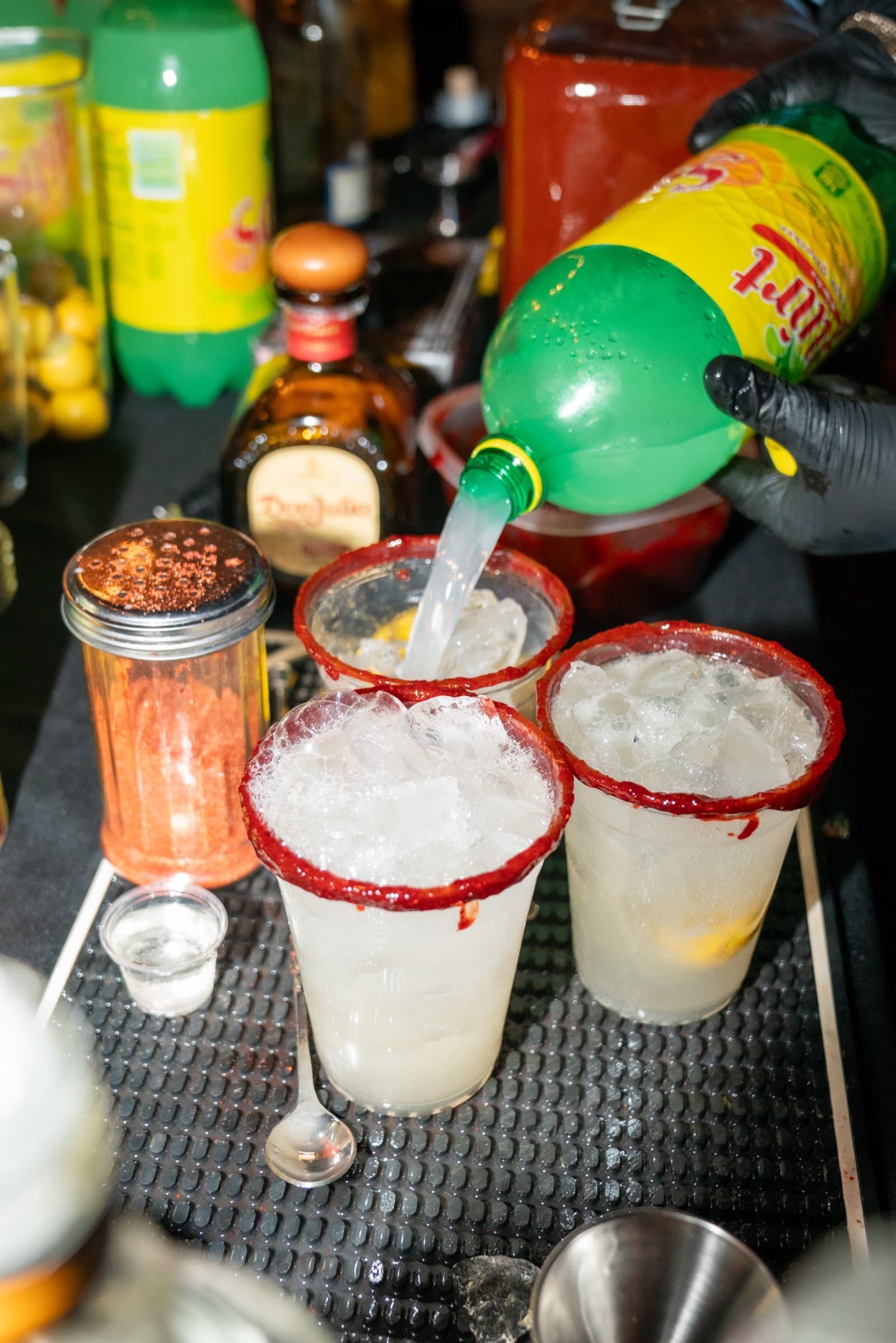Bartender pouring Jarritos into a chamoy-rimmed cup at a Rimdrip event