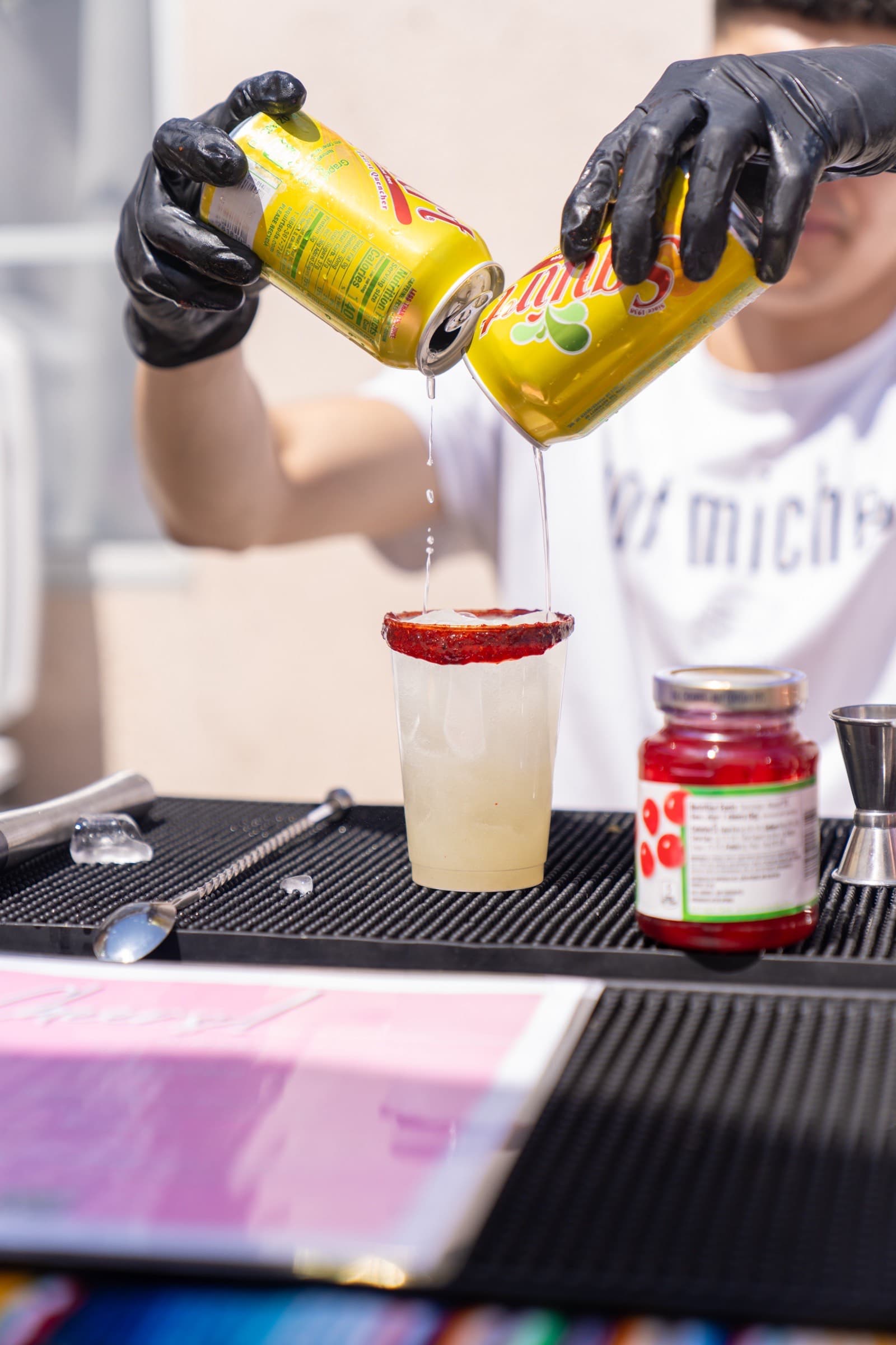 Bartender pouring Mike's Hard into a chamoy-rimmed cup